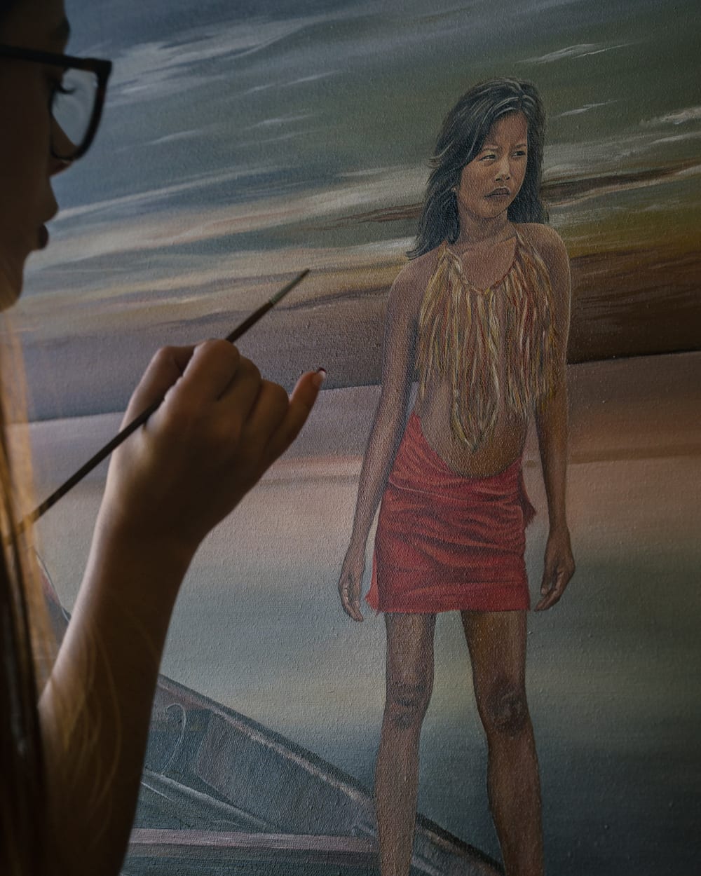 Valeria painting Guerrera, brush in hand.