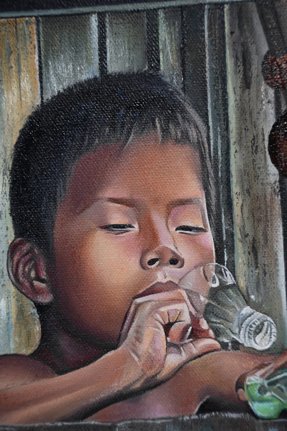 Detail of Inocencia: a boy drinking from a glass.