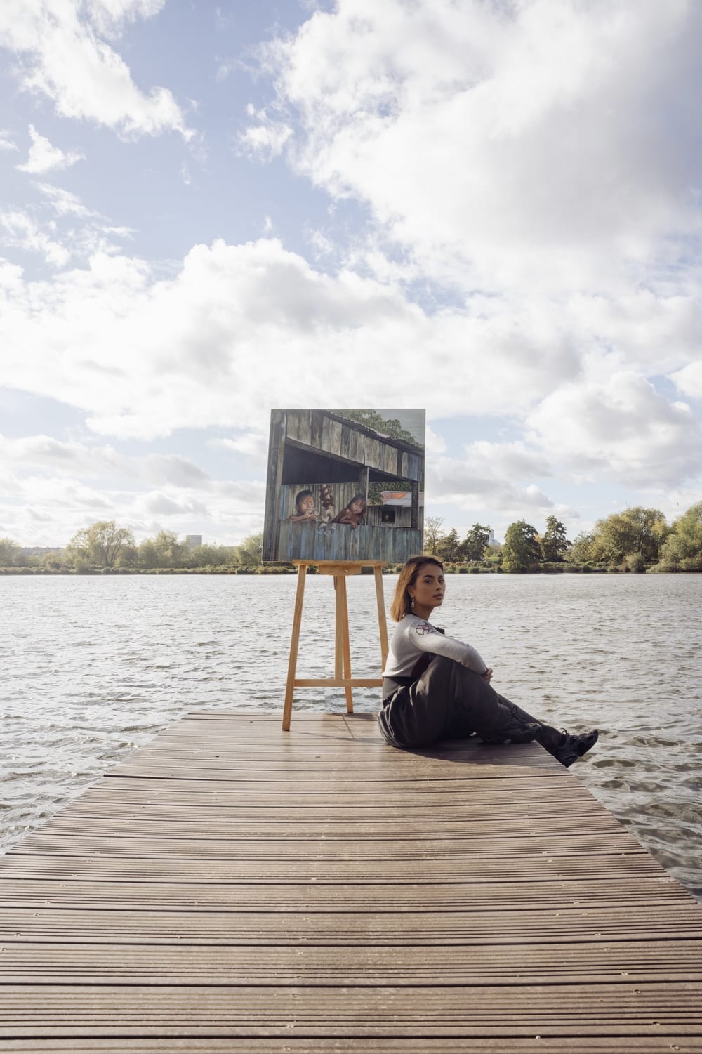 Valeria sitting on a jetty beside Inocencia on its easel.