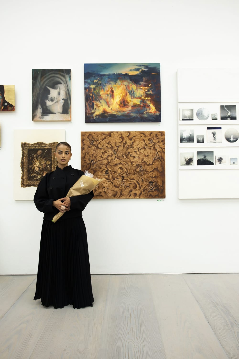 Valeria holding flowers in the exhibition at Saatchi Gallery.