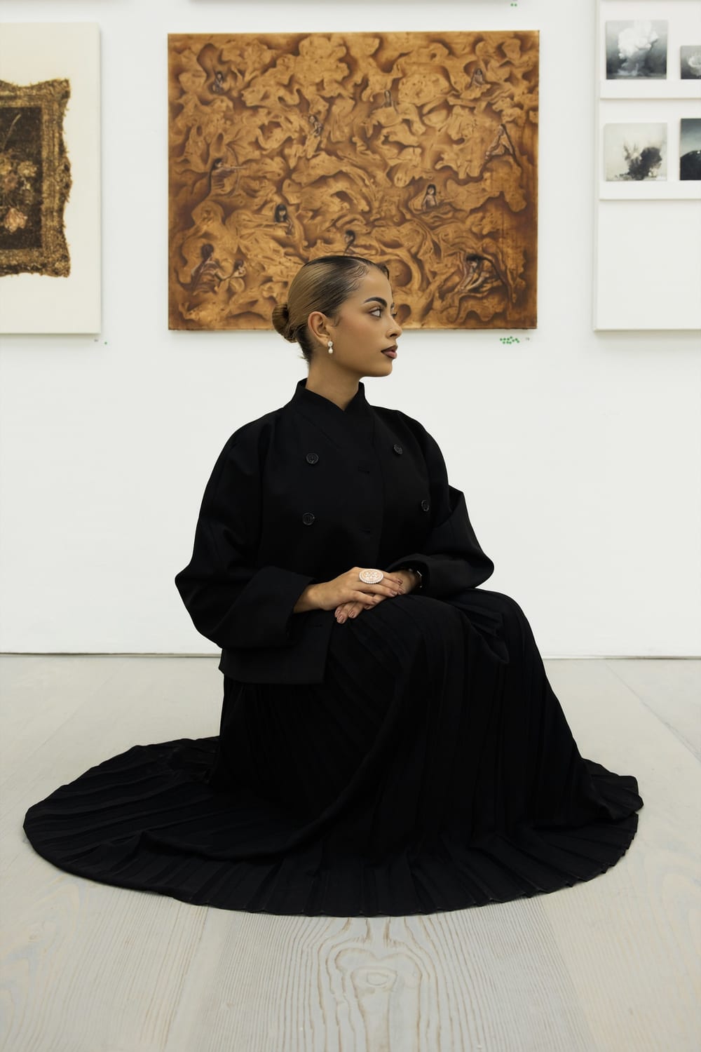 Valeria seated on the floor in front of Pachamama at Saatchi Gallery.