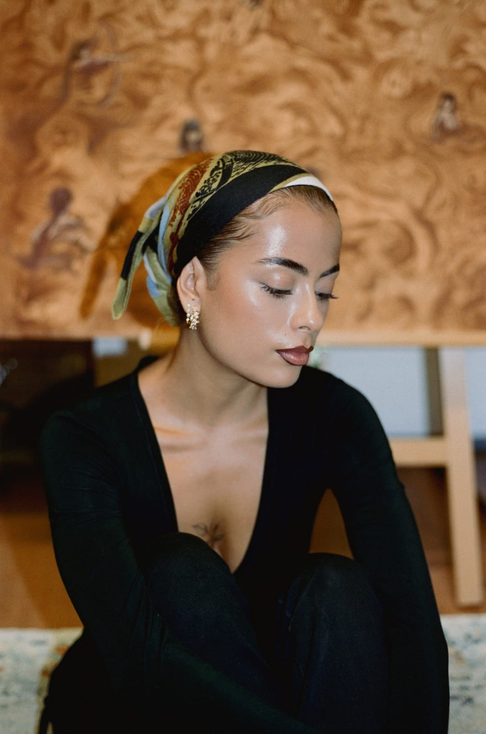 Valeria in a silk headscarf, Pachamama behind her.
