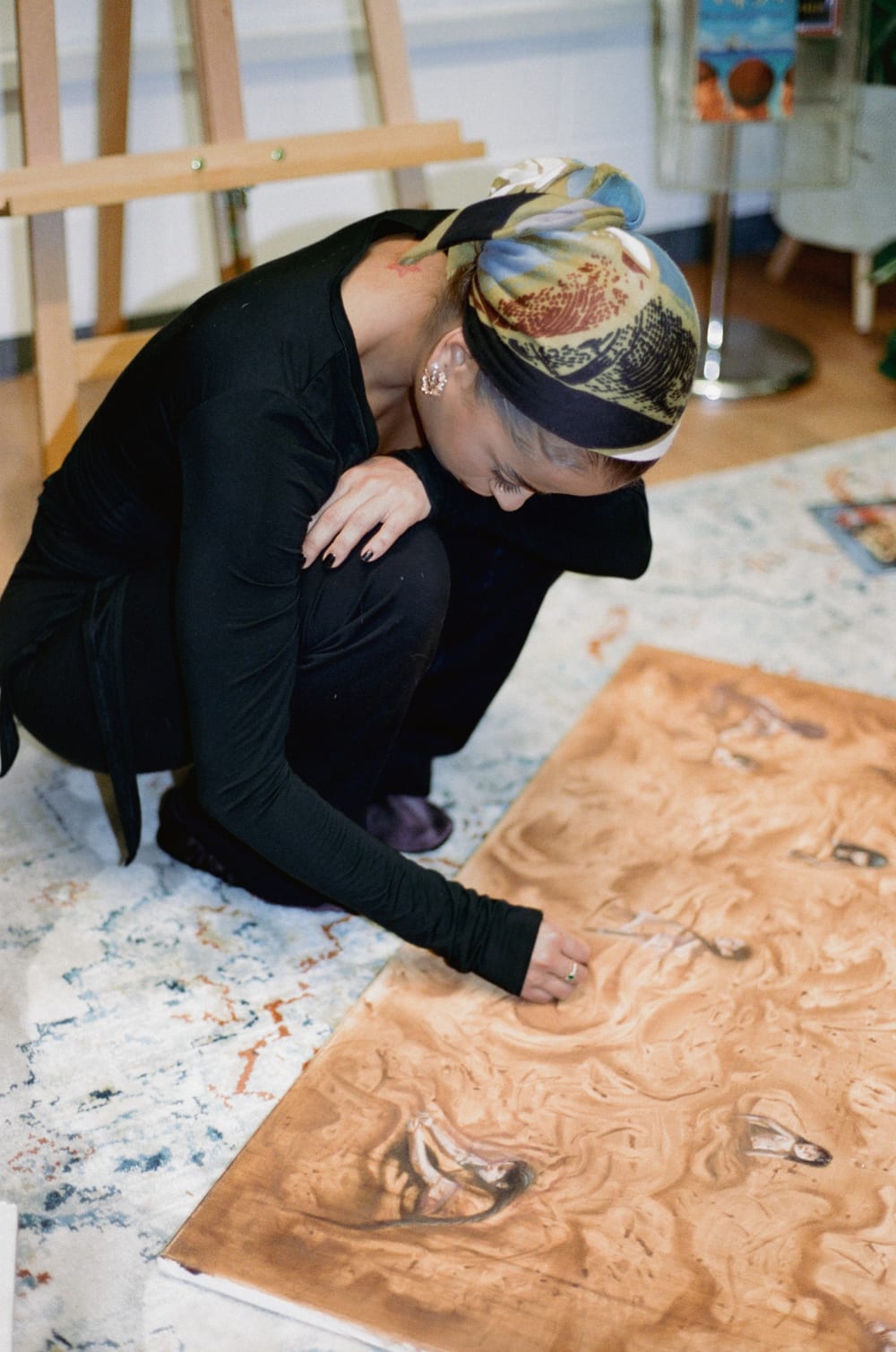 Valeria crouching over Pachamama laid on the floor.
